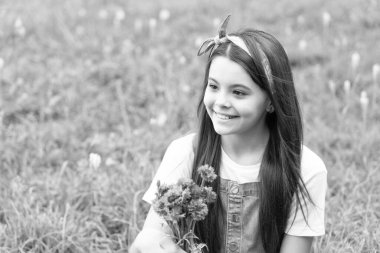 Bahar çiçekleriyle çimenlerin üzerinde mutlu bir kız. Boşluğu kopyala.