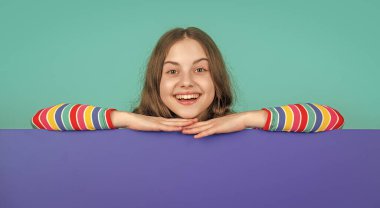 Boş mavi kağıdın arkasında reklam için fotokopi alanı olan gülen çocuk..