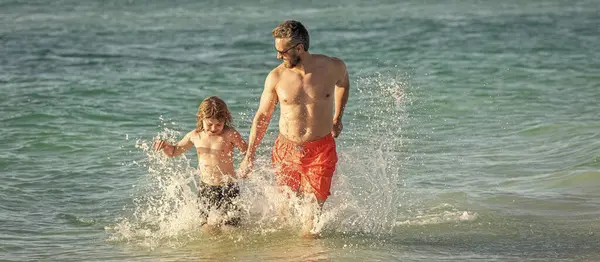 stock image Father son child bonding enjoying summer vacation. Special moments between daddy and son at sea. Father son kid bonding relationship. daddy and son running in sea beach. happy family.