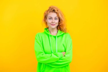 Kapüşonlu kadın sarıda izole edilmiş. Moda modeli. Şık kapüşonlu kızıl saçlı kız. Sıradan kapüşonlu, şık, beyaz bir kadın. Moda kızı modaya uygun ve parlak görünüyor..