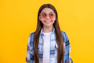 Kareli gömlek giyen mutlu bir genç kız. Uzun saçlı genç kız. Gündelik tarzda genç bir kız. Güneş gözlüklü genç kız. Moda düşkünü gençler..