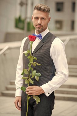 valentines day concept. handsome tuxedo man with valentines rose. flower gift for valentines day.
