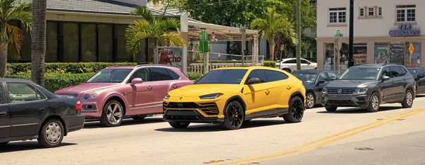 Miami Beach, Florida USA - April 15, 2021: Bentley Bentayga v8 2015 and Lamborghini Urus on road.