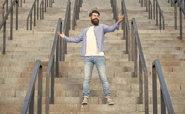 cheerful hipster downstairs. full length of hipster with beard. hipster man outdoor at stairs.