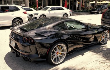 Miami Beach, Florida USA - April 15, 2021: black ferrari F12 berlinetta supercar, side corner view.
