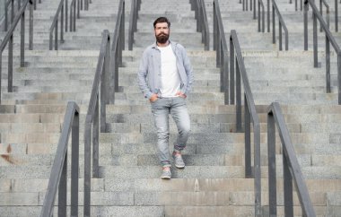 Sakallı adam aşağı iniyor. Sakallı bir adam. Hipster adam merdivenlerden aşağı in..