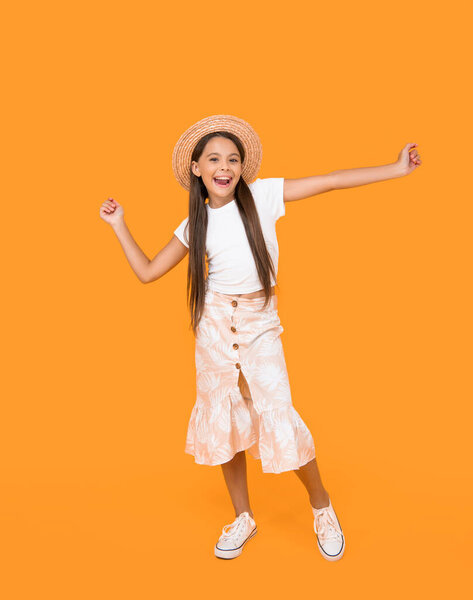 happy teen girl in straw hat having fun on yellow background.