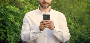 İnternette çalışan iş analisti. İnternette çalışan iş analistinin kesilmiş fotoğrafı. İş analisti internette çalışıyor. İş analisti açık havada telefonla çalışıyor..