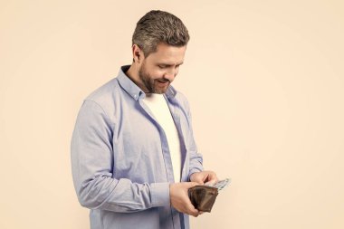 Stüdyoda para kazanan pozitif bir adam. Para kazanan banknotları olan bir adam. Para kazanan bir adamın fotoğrafı. Para kazanan bir adam stüdyo geçmişinde izole edilmiş..