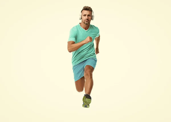 stock image confident sport jogger listen to music in headphones. The jogger ran at sport training isolated on white. In a morning sport workout jogger run in studio. The jogger stretched legs before running.