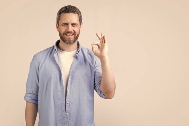 Neşeli, mükemmel bir adam, iyi bir jestle Grey 'de izole edilmiş. Stüdyoda iyi bir jest yapan mükemmel bir adam. Harika bir jestle mükemmel bir adamın fotoğrafı. Mükemmel jestli bir adam..