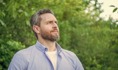 Tıraşsız yakışıklı bir adamın portresi doğal arka plan, kopyalama alanı..