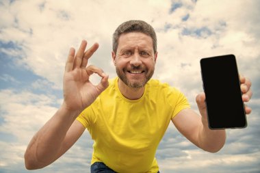 Mutlu adam akıllı telefon ekranına kopyalama alanı sunuyor. Tamam.