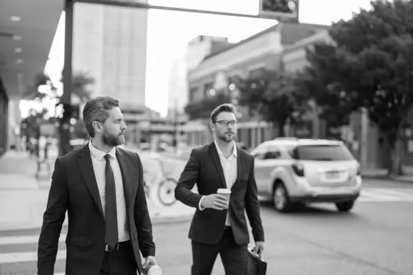 selective focus of businessmen walk in the street. businessmen walk outdoor. businessmen walk in suit. photo of businessmen walk together.