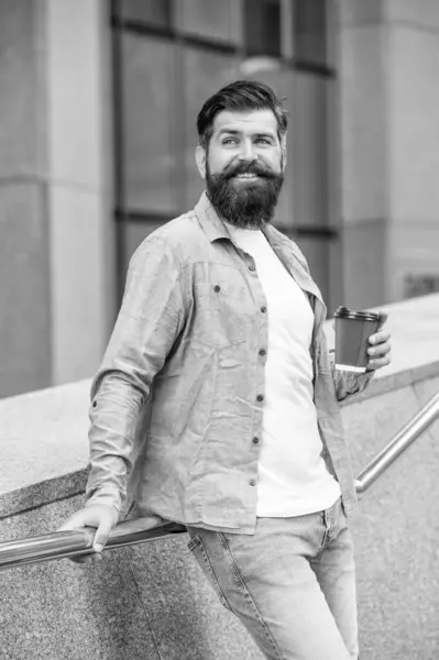 happy man drinking coffee outdoor. man drinking coffee outside. man drinking coffee in the street. photo of man drinking coffee.