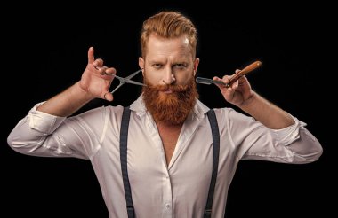 face of barber man in studio. barber man with scissors and retro razor blade. photo of barber man on background. barber man isolated in black.