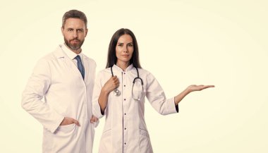 Terapist doktor ve hemşire ürünleri stüdyoda sunuyor. Terapist doktor ve hemşirenin fotoğrafı beyaz önlük giyiyor. Doktor terapist ve steteskoplu hemşire. Doktor ve hemşire beyazlar içinde..