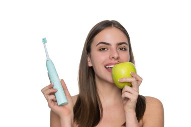 Dişlerini fırçalayan bir kız. Beyaz dişler. Diş sağlığı kliniği. Elektrikli diş fırçası. Beyaz tenli dişlek kadın gülüşü. Dişlerini elektrikli diş fırçasıyla fırçalayan bir kadın. Yumuşak diş fırçalama.