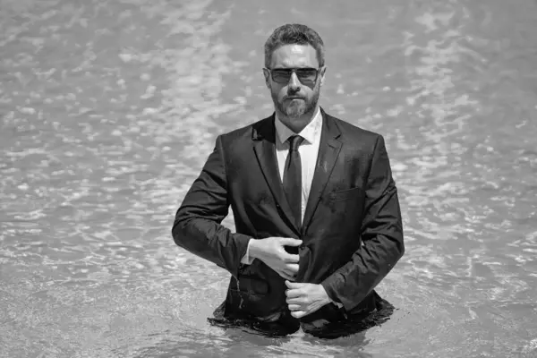 photo of businessman boss relax in summer pool with copy space. businessman boss in summer pool on vacation. businessman boss in summer pool outdoor. businessman boss in summer pool wearing suit.