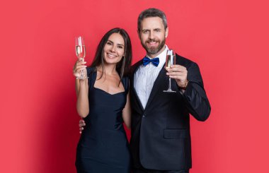 Sevgililer Günü. Yıldönümünü kutlayalım. Aşık çift nişanı kutluyor. Zarif çift kırmızıda izole edilmiş şampanya içer. Resmi olarak bir çift. Romantik randevu kutlamaları.