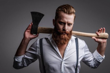 Sakal şekillendirme. Bıyıklı, Kafkas bir hippi. Sakallı adam gri yolda izole edilmiş. Sakallı adam, baltayı tut. Saç ve sakal bakımı. Yakışıklı, sakallı, vahşi adam..