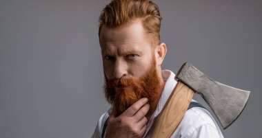 Sakallı ve bıyıklı, beyaz, vahşi bir adam. Erkeksi enerji. Retro tarzı. Yakışıklı ve karizmatik. Erkeksi adam. Yüz portresi. Baltası gri renkte olan sakallı adamın erkekliği..