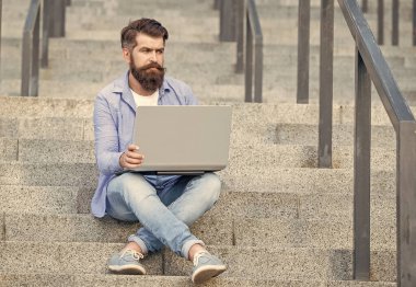 Adamın dışarıda online bilgisayar iletişimi var. Adamın dışarıda çevrimiçi video bağlantısı var. Adamın merdivenlerde online video bağlantısı var. Adamın dizüstü bilgisayarında video bağlantısı var..