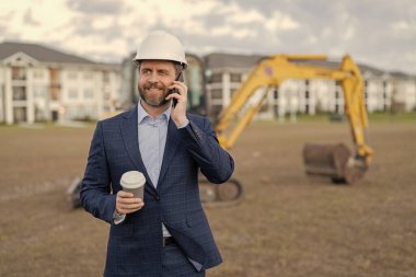 İnşaat yatırımcısının imajı. Telefonu olan iş adamı inşaat yatırımcısı. Kahve molasında iş adamı inşaat yatırımcısı. İş adamı inşaat yatırımcısı..