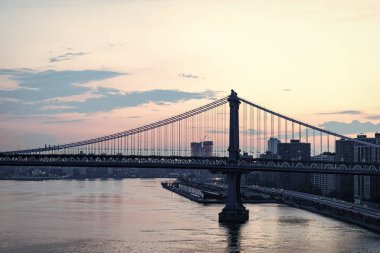 Brooklyn Köprüsü. New York mimarisi. Brooklyn Köprüsünden Manhattan 'a. Brooklyn Köprüsü 'nün şehir mimarisi simgesi. Metropolis şehrinin mimarisi. East River Köprüsü 'nün panoramik görüntüsü.