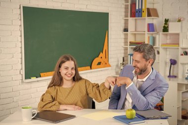 Sınıfta öğretmenle birlikte neşeli çocuk eğitimi. Yumruk yumruğa.