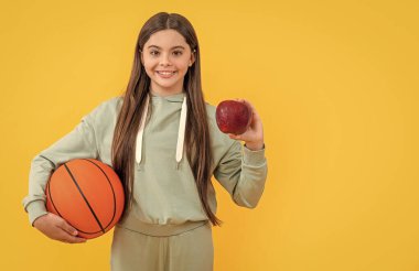 Genç basketbolcu kız sarıda izole edilmiş. Stüdyoda genç basketbolcu kız. Arka plandaki genç basketbolcu kız. Elmalı genç basketbolcu kızın fotoğrafı.