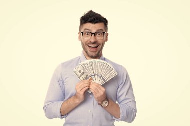 Excited guy holding paper money studio. Rich guy smiling with money banknotes. Personal loans. Cash money for lending. Making and spending money.