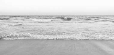 Deniz suyu dalgaları ve sabah gökyüzü olan güzel bir sahil..