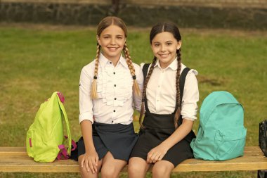 back to school. two glad teen children after school outdoor. friendship of school girls.