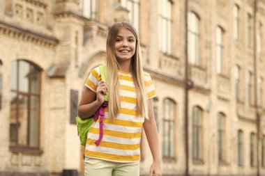 Happy smiling teenage girl standing at school blurry outdoors, education.