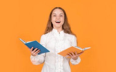 Şaşırmış çocuk kitabı okuyor. Okula dönüyorum. Çocukluk eğitimi. Bilgi günü. Çocuk defteri tut. Lise öğrencisiydim. Genç kız ödevlerini defterle yapıyor. çalışma kitabıyla çalış.