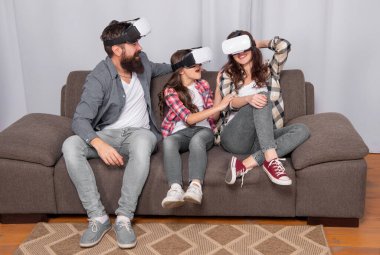 Mutlu ebeveynler ve küçük kız modern teknolojiyi kullanıyorlar. Anne, baba ve kızı. Gelecek ve yenilik. Modern hayat. Baba, anne ve çocuk kablosuz sanal gerçeklik gözlüğü. sanal gerçeklik ailesi.