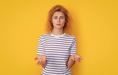 Sarı arka planda izole edilmiş üzgün kızıl saçlı kadın portresi. Stüdyodaki genç kızıl saçlı kadının portresi. Yetişkin kızıl kadın portresi.