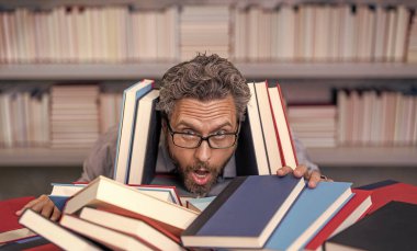 Çok çalışan erkek öğrenci kitapçıda ya da okul kütüphanesinde kitap okuyor. Okulda edebiyat öğretmeni ve kitap. Bilgi günü. Okul sınavına hazırlan. Çok çalışan milenyum öğrencisi kitap okuyor. Dinlenmem gerek..