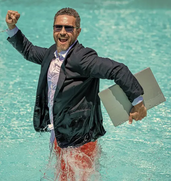 successful man. Businessman in suit with laptop in swimming pool. business man on summer vacation. businessman in wet suit in swim pool. Remote working. Summer business dreams. Fun business lifestyle.