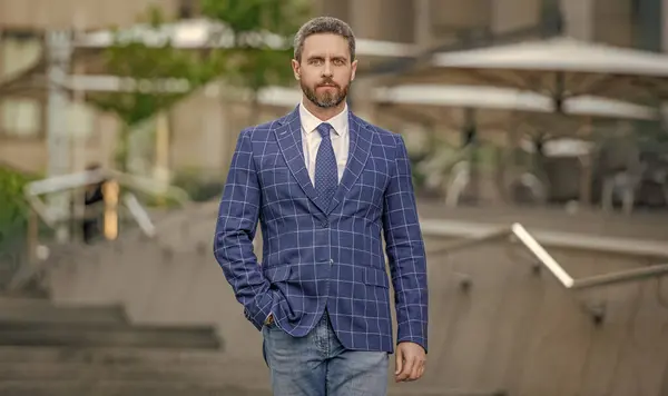 businessman walking on urban background. businessman wearing jacket in the street. photo of businessman with tie.businessman outdoor.
