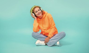 Kadın imajının müzik tarzı var. Kulaklık takıyor. Kadının müzik yaşam tarzı mavi üzerine izole edilmiş. Kadının stüdyoda müzik tarzı var. Kadının arka planda müzik tarzı var..