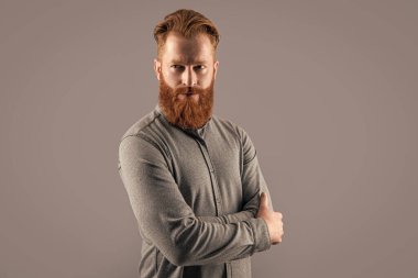 Kendinden emin İrlandalı adam. Sakallı ve bıyıklı adam. Ciddi tıraşsız adam kollarını çapraz tutuyor..