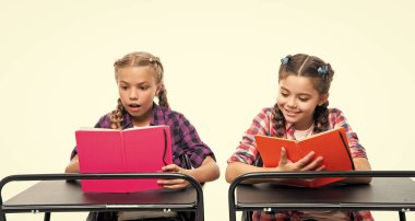 Okul çocukları kitapla çalışır. Okul çocukları sınıfta ders çalışır. Lisede eğitim. Kızlar ödevlerini yapmak için kitap tutuyorlar. Okula dönüyorum. Bilgi yolculuğu.