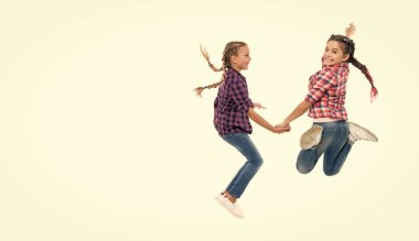 Çocuklar birlikte eğleniyor. Kardeşlik ve dostluk bağı. Kız arkadaşlar eğleniyor ve zıplıyorlar. İki çocuğun arkadaşlığı. Mutlu kızlar kardeşliği. Kız kardeşliğin sonsuz gücü. Boşluğu kopyala.