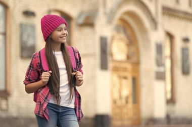 Happy schoolgirl back to school outdoors, copy space.