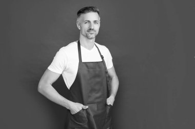 Kırmızı arka planda önlüklü olgun bir aile reisi.