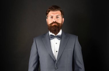 Mavi smokinli ciddi bir adam. Siyah arka planda resmi giyinen bir adam. erkek resmi moda.