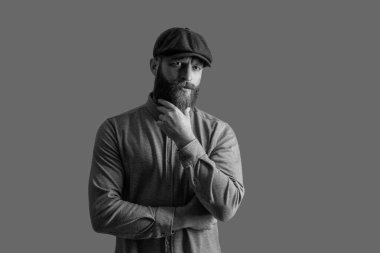 İrlandalı adam gri yolda izole edilmiş. Kızıl sakalı okşayan ciddi bir adam. Sakallı adam stüdyosu.