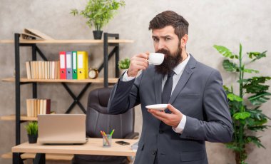 İş adamı kılığındaki acımasız CEO, sabah kahve fincanıyla öğle yemeği molası veriyor..